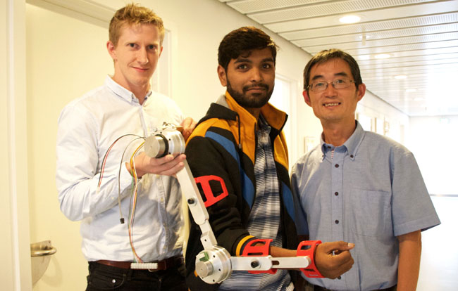 Exoskeletter skal sørge for, at ældre kan holde sig aktive og mobile i fremtiden. Simon Christensen (tv.), Muhammad Raza Ul Islam og Shaoping Bai (th.) med første model af en bærbar robotarm. Foto: Jakob Brodersen.